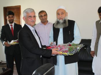 Dr Shaha Jehan khan, VC Iqra National University is presenting guldasta (flowers ) to Chairman HF